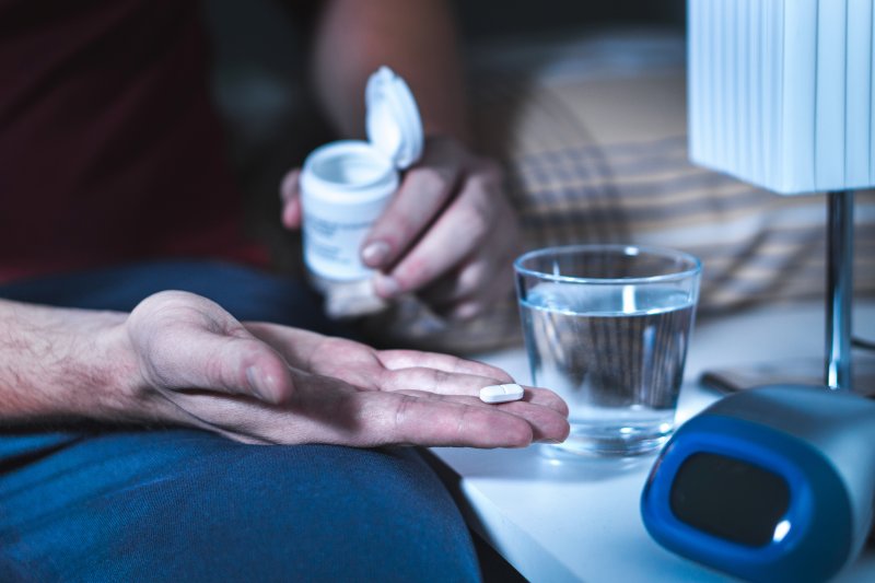 man holding sleeping pills in hand